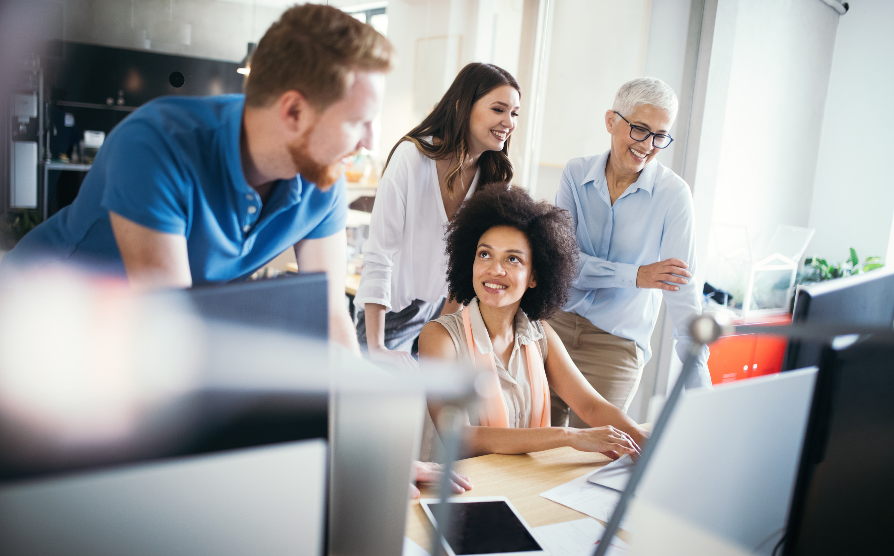 Team collaborating around a computer in a modern office