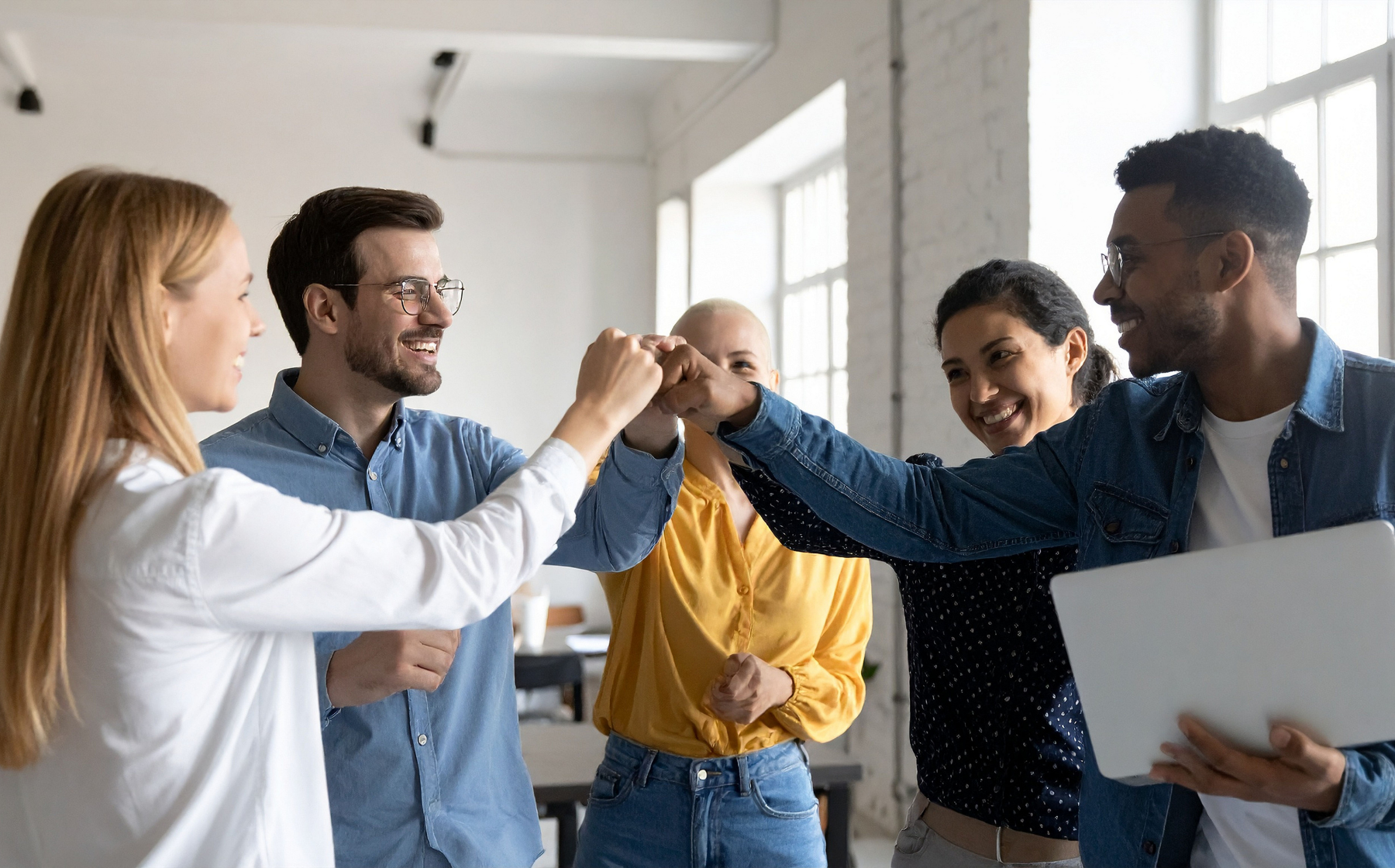 Diverse team celebrating with a group fist bump