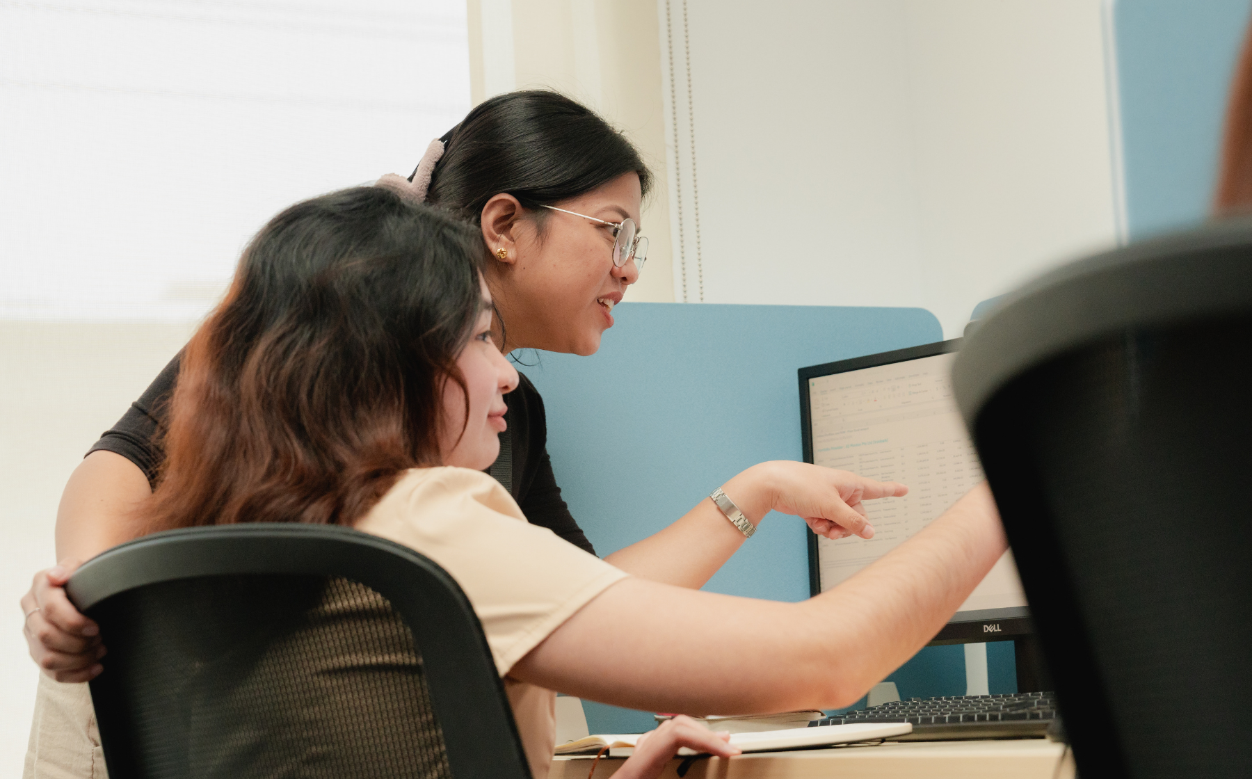 Two team members reviewing information together at a computer workstation