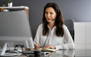 Woman wearing a headset takes notes during a video call