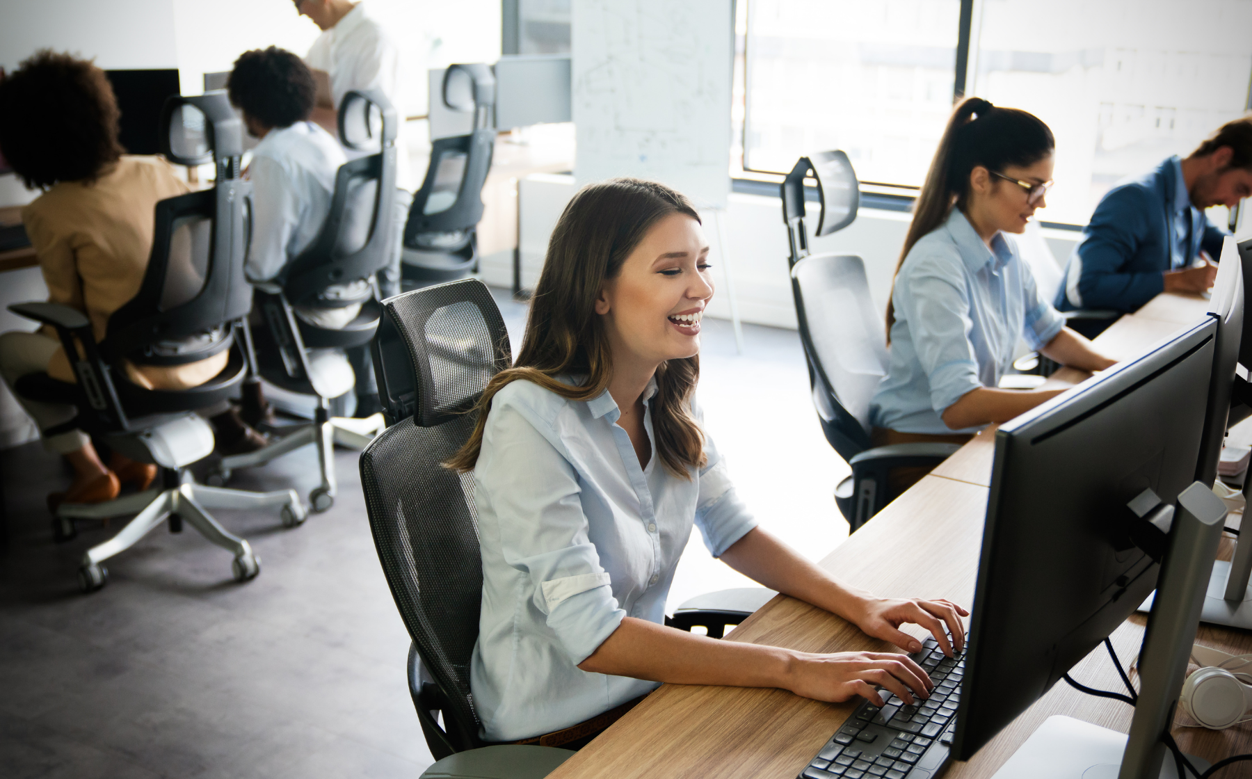 Customer service team working at computers in a modern office