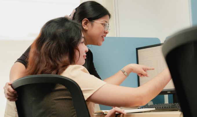 Team members collaborating at a computer