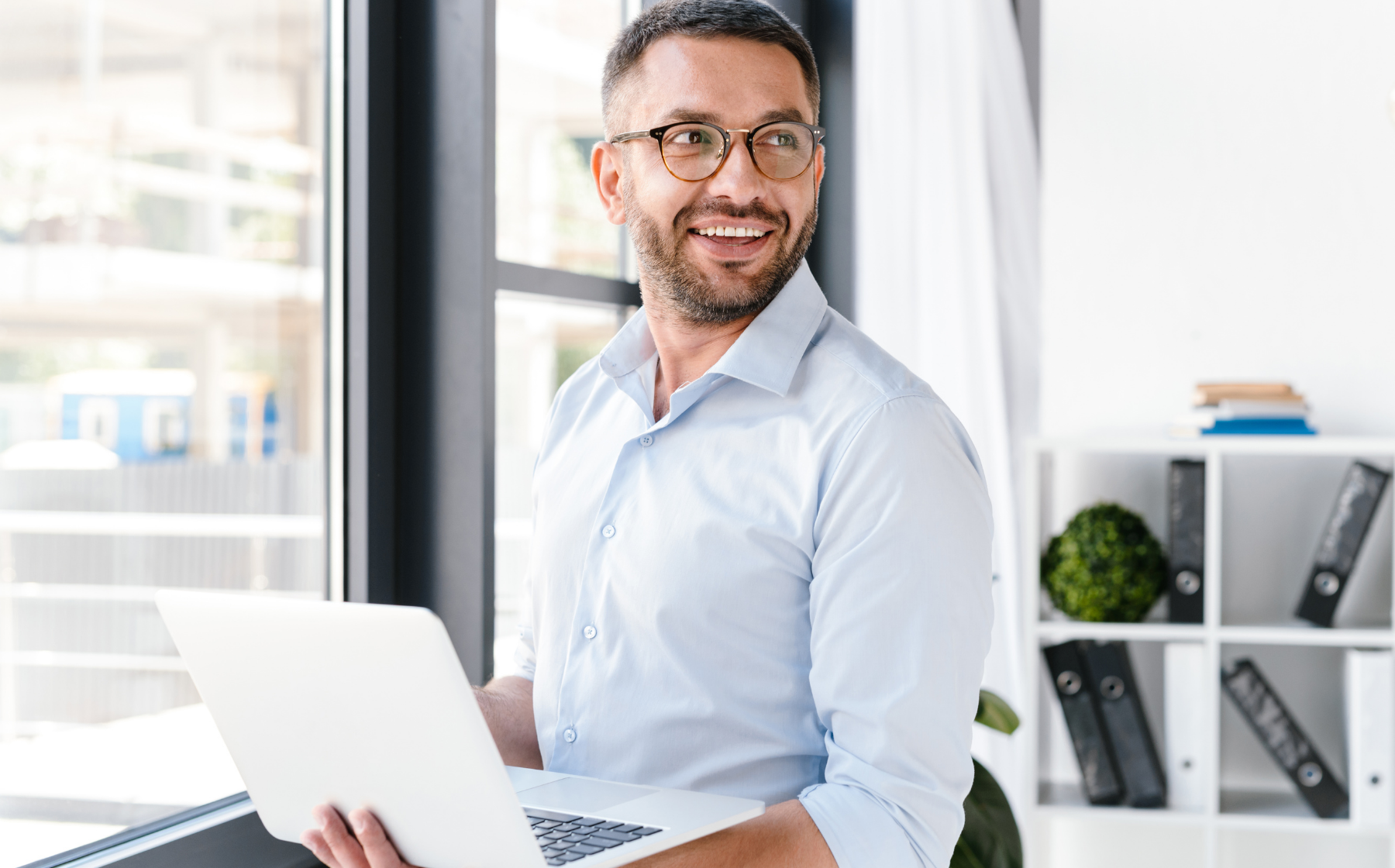 Business professional working on a laptop in a bright office